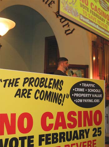Joe Catricala, coordinator of Don’t Gamble on Revere, is flanked with yellow ‘No Casino’ signs last week.